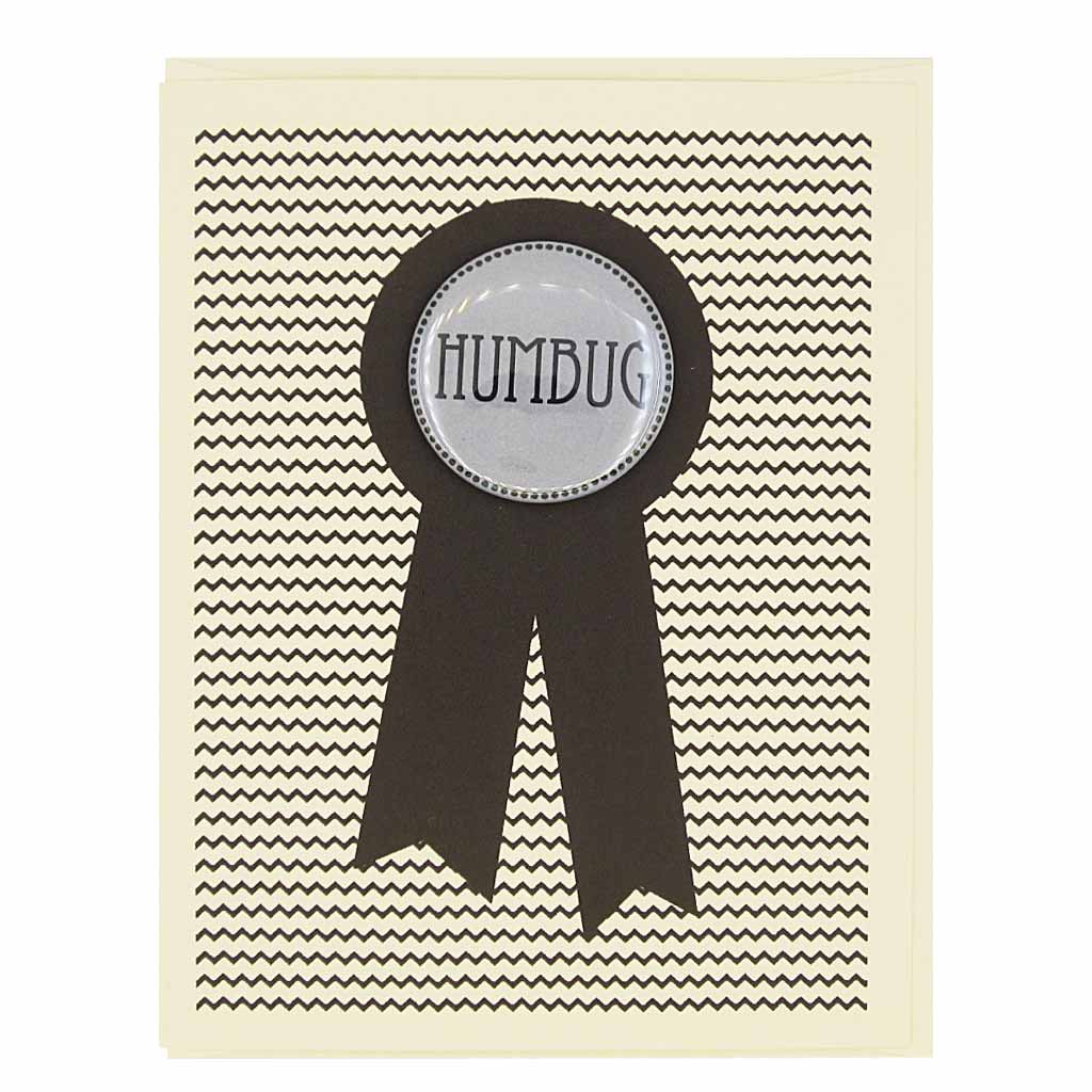 This card is perfect for the holiday curmudgeon in your life. Features a 1½” button that says "humbug" that can be taken off and proudly worn by the recipient. Card measures 4¼” x 5½”, comes with a cream envelope & is blank inside.